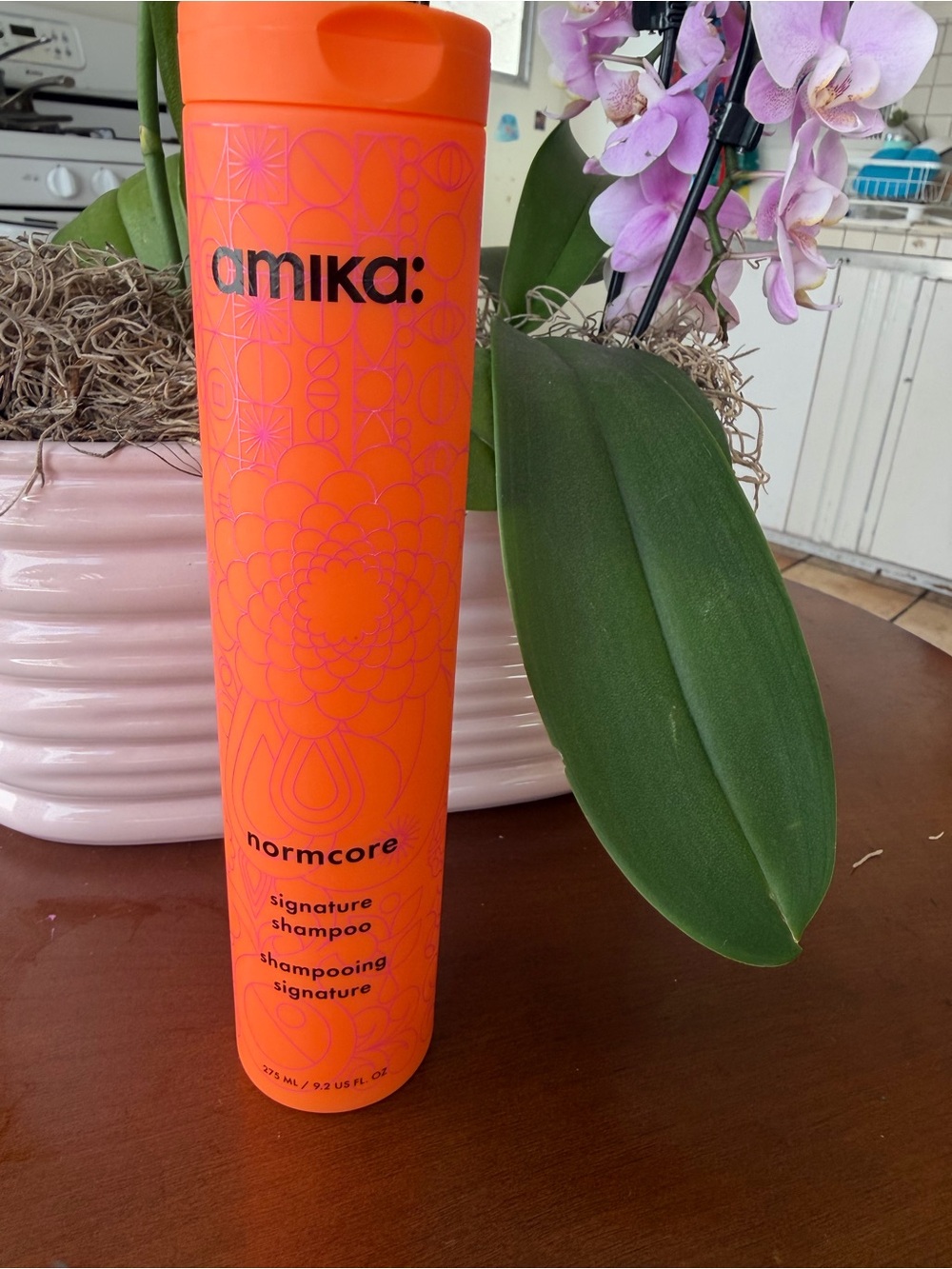 amika orange bottle with pink geometric label 9.2 fl oz